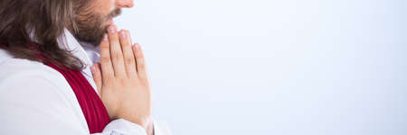 Thoughtful Jesus Christ wearing white robe and prayingの写真素材