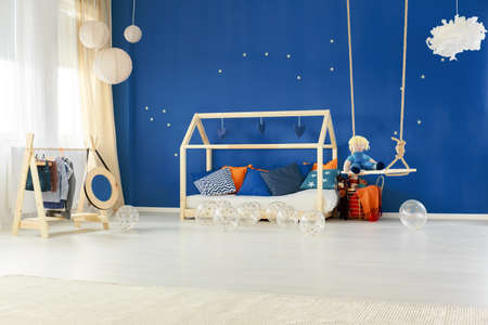 Child bedroom with diy wooden house bed and blue wallの写真素材
