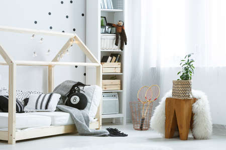 White cozy baby room with wooden furniture and black additionsの写真素材