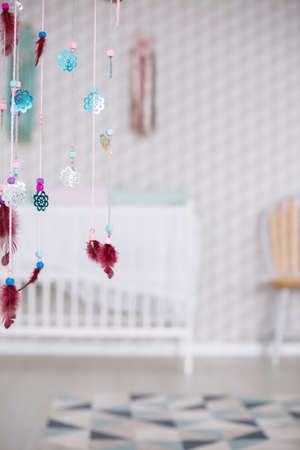 Colorful boho decoration in simple and modest white baby roomの写真素材