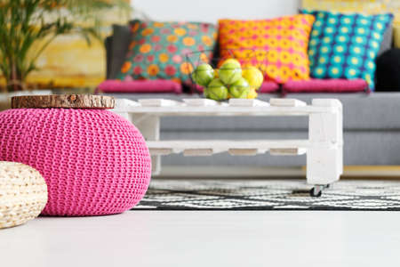 Interior with pink pouf, colorful cushions, grey couch, diy tableの写真素材