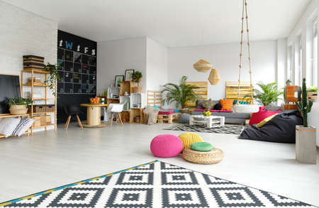 Modern apartment with colorful poufs, sack chair and pattern carpetの写真素材