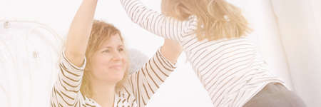 Loving mother and daughter playing together, panorama