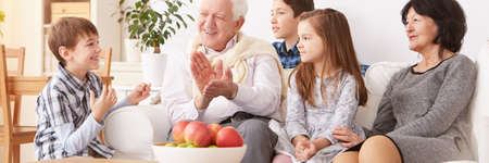 Young boy telling the story in front of grandparents and siblings