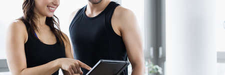 Woman planning workout routine with her personal trainerの写真素材