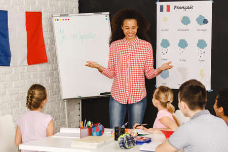 Smiling native speaker during French lesson with kids