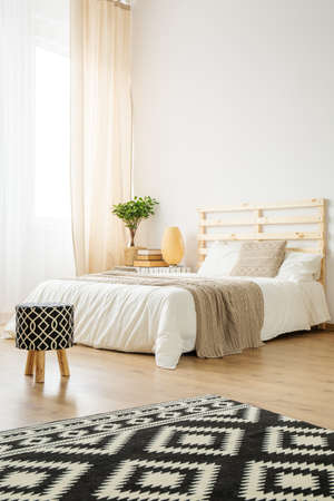 Double bed in cozy modern bedroom full of lightの写真素材