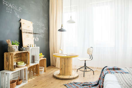 Modern eco studio apartment with crates, table and bed