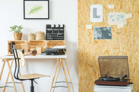 Modern room with desk, record player, posters and osb boardの写真素材