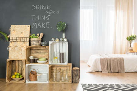 Stylish studio apartment interior with wooden crates and double bedの写真素材