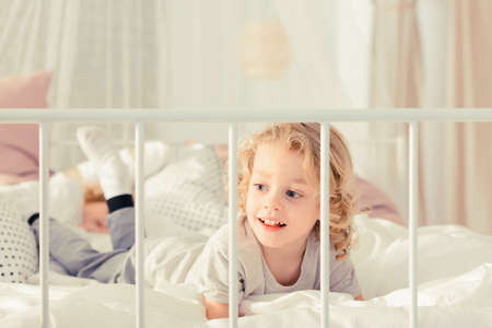 Little boy laying on the bed and smilingの写真素材