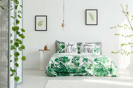 Botanical bedroom with white wall, double bed, leaf beddingの写真素材
