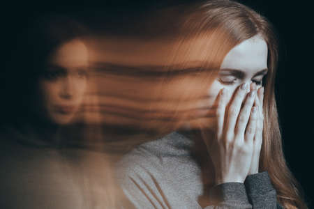 Young woman with emotional problems covering her face, cryingの写真素材
