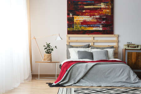 Up-to-date decor of spacious bright bedroom with poster and bed