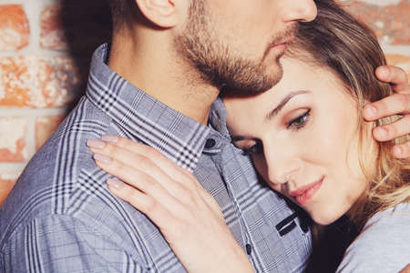 Close-up of young woman holding her head on her boyfriend's chestの写真素材