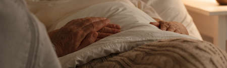 Senior people holding hands on a bedの写真素材