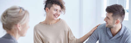 Smiling couple looking at each other during marital therapy session
