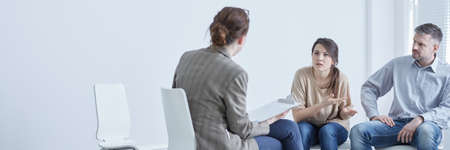 Angry woman complaining about husband to therapist during marriage therapyの写真素材