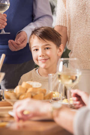 Little boy sitting at the table at the family dinnerの写真素材