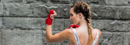 Female boxer training in red boxing gloves