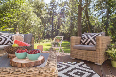 Beautiful wooden terrace with patterned pillows in the garden