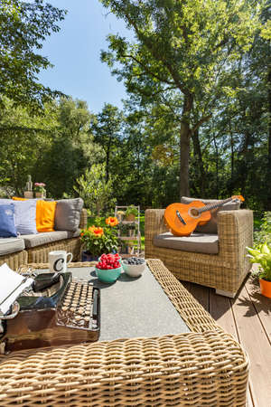 Cozy garden with wicker furniture on a sunny summer day