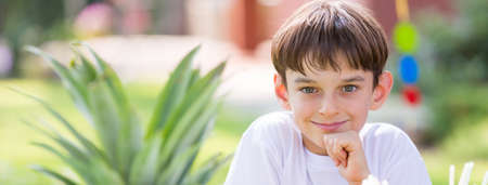 Portrait of young smiled boy sitting outsideの写真素材