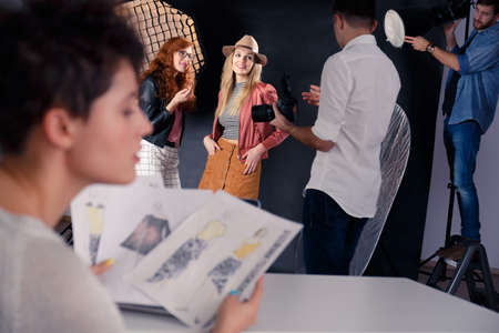 Fashion models talking with photographer during photoshootの写真素材