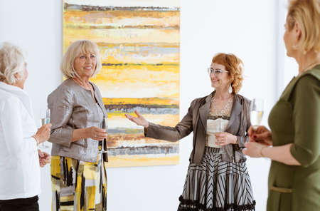 Elegant woman presenting the artist of the paintingsの写真素材