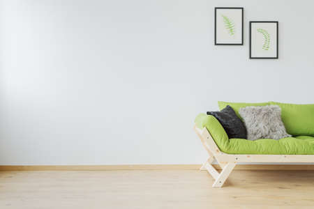 Wooden scandi designed sofa and copy space on white wallの写真素材