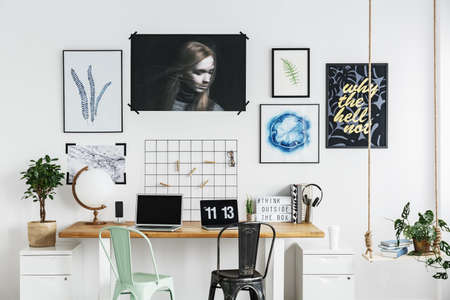 Posters on a white wall in modern home officeの写真素材