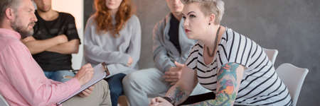 Young people having group meeting during addiction treatment