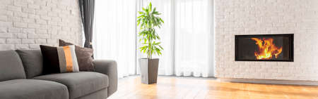 Spacious white and wooden living room with fireplace in wallの写真素材