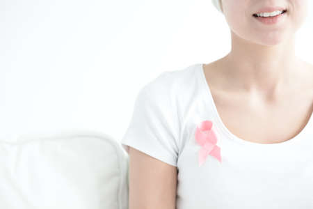 Woman wearing pink ribbon on white shirt