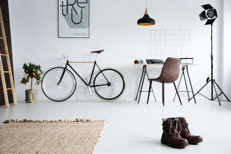 Classic studio interior with desk, bike and man's bootsの写真素材