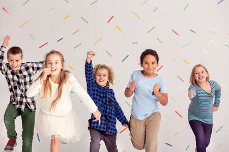 Group of young happy friends running aheadの写真素材