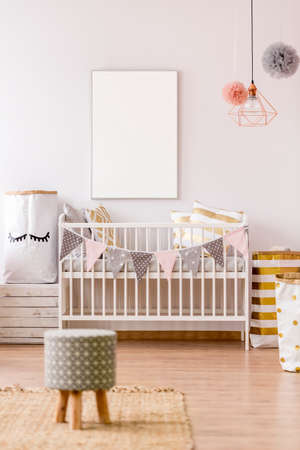 White frame mockup in cozy pastel baby nursery interiorの写真素材