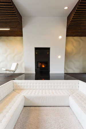 White stylish sofa built in the wooden floor in spacious modern lounge