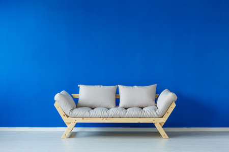 Simple blue living room with wooden bright sofaの写真素材