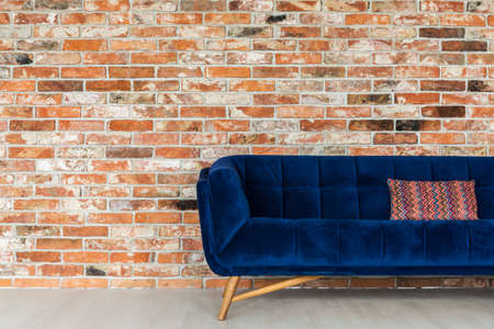 Navy blue sofa and ethnic pillow on itの写真素材