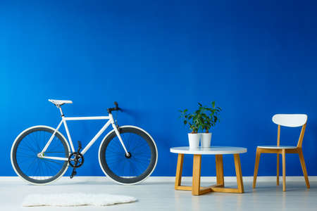 Set of table and chair in blue room with bicycleの写真素材
