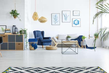 Spacious living room with sofa, armchair and posters