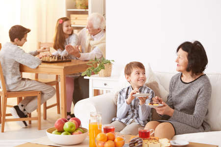 Beautiful grandmother and her happy grandson eating delicious, homemade cakeの写真素材