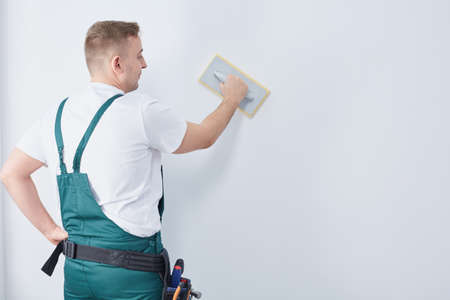 Young but experienced worker is performing renovation in the room