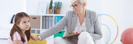 Female school psychologist helping little girl with problemsの写真素材