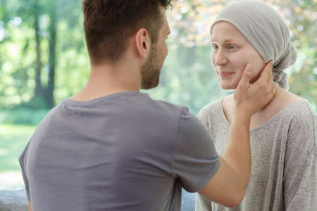 Loving husband touching his sick wife's smiling face