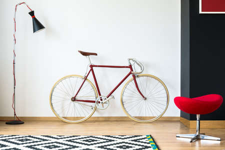 Red and stylish cycling hipster bike in apartmentの写真素材
