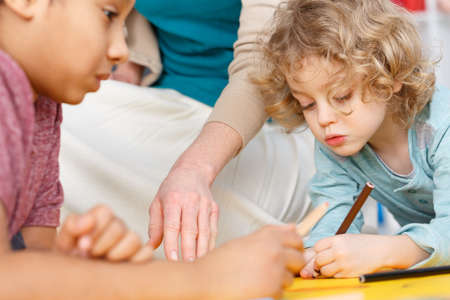 Close-up of two boys drawing during art classes