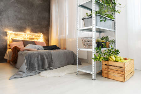 Young woman with red hair lying on cozy bed in stylish modern apartmentの写真素材