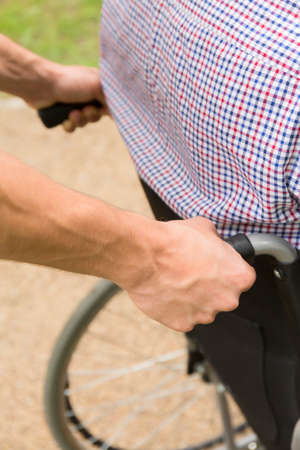 Close up of a man pushing a disabled person on wheelchairの写真素材